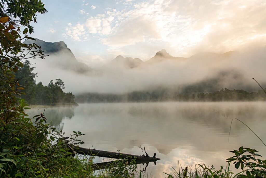 धुंध से ढकी पहाड़ियों और गहरी घाटियों वाला दृश्य, जो शांगरी-ला घाटी के वास्तविक होने या कल्पना मात्र होने के रहस्य को प्रतीकात्मक रूप में दर्शाता है।